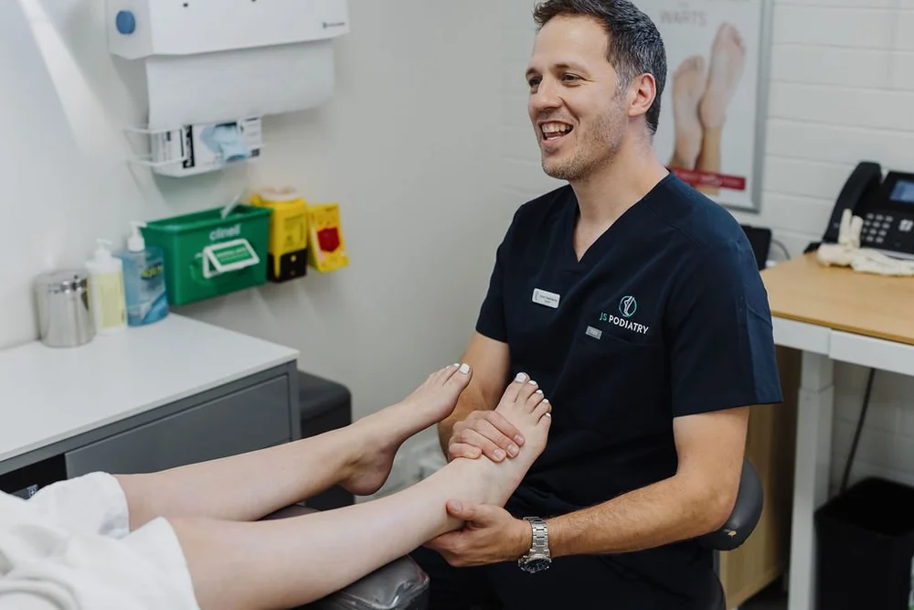 A podiatrist assessing the joints of a patient's foot and ankle