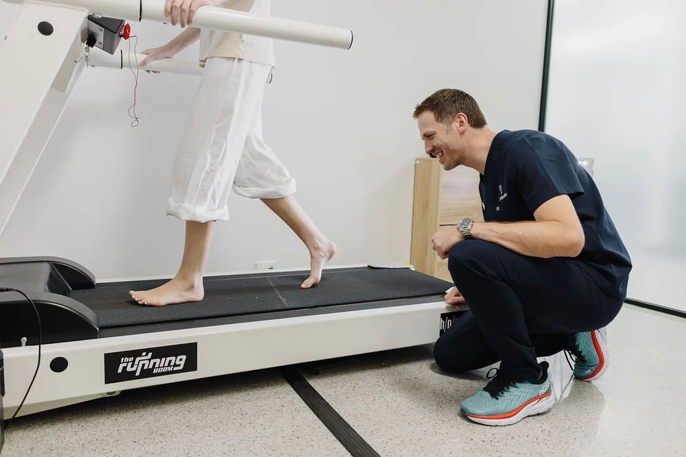 A podiatrist observing a patient walking on the clinic treadmill