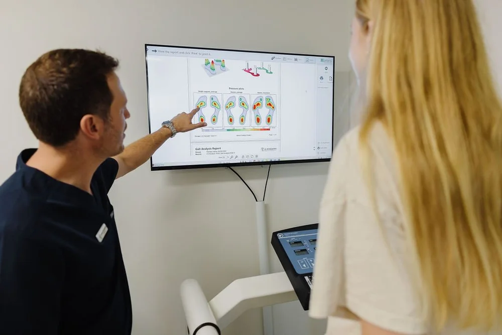 A podiatrist explaining a gait analysis report to a patient