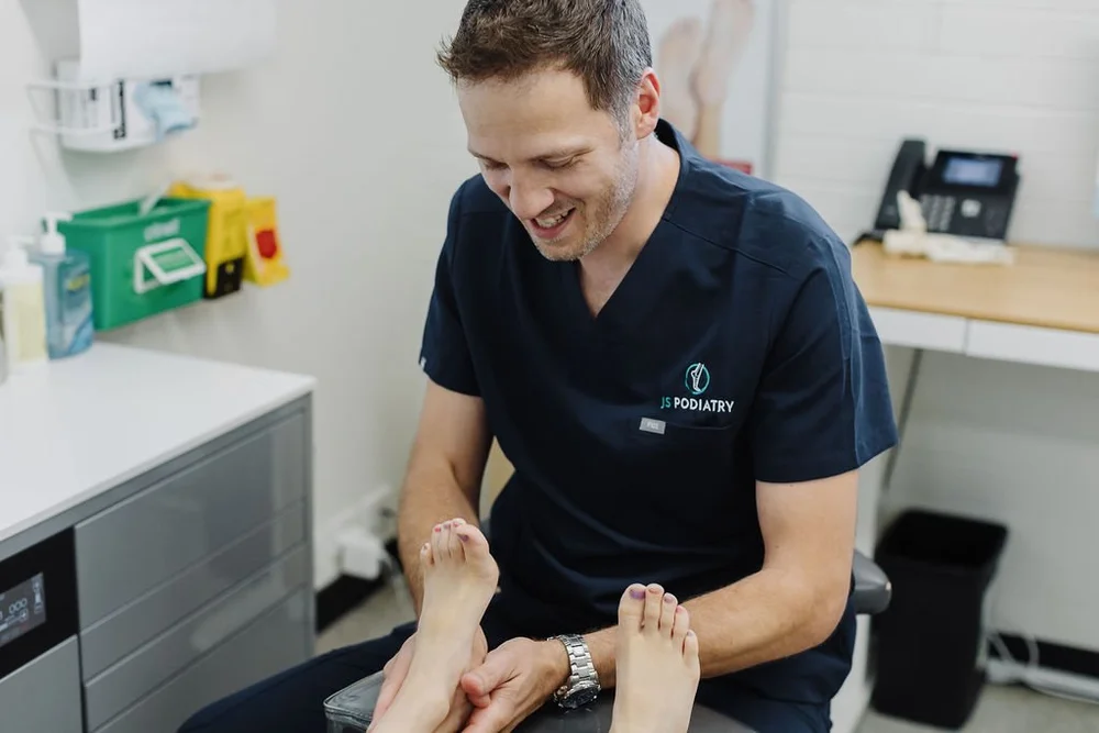 A podiatrist checking a patient's foot during a routine appointment
