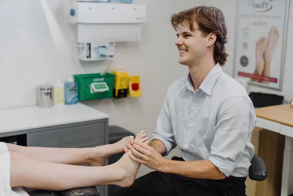 A podiatrist examining a patient's forefoot