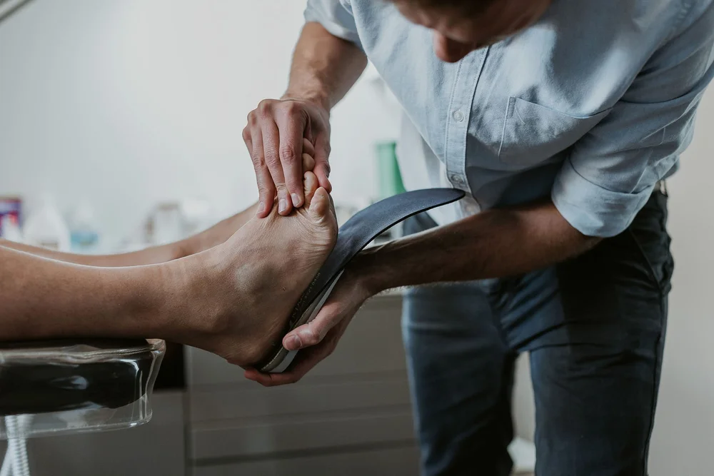 JS Podiatry podiatrist checking the fit of a custom orthotic