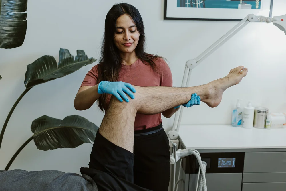 A podiatrist supporting a patient's leg with strapping applied to the foot