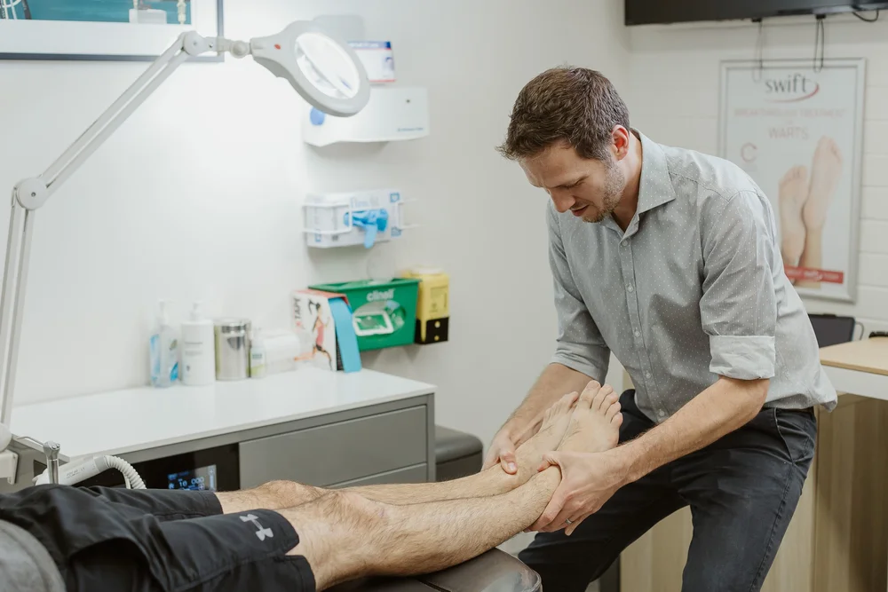A JS Podiatry podiatrist assessing a patient's ankle and heel in the East Perth clinic