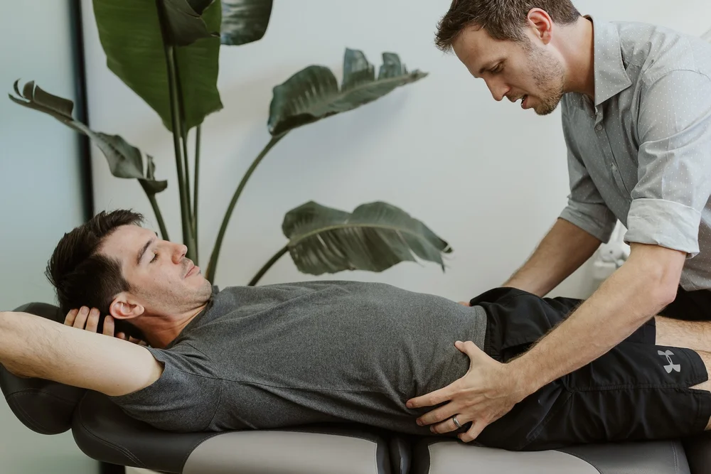 A podiatrist treating a patient's lower leg on the treatment couch