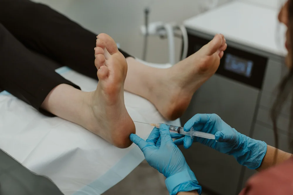 A podiatrist delivering an injection to the foot in the East Perth clinic