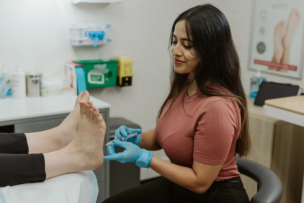 A podiatrist examining the forefoot of a patient