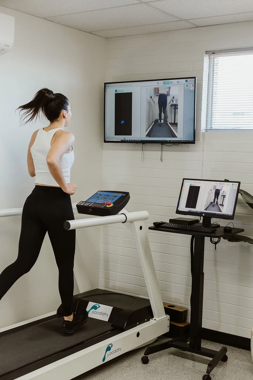 Patient running on the Zebris treadmill during a 3D gait analysis at JS Podiatry