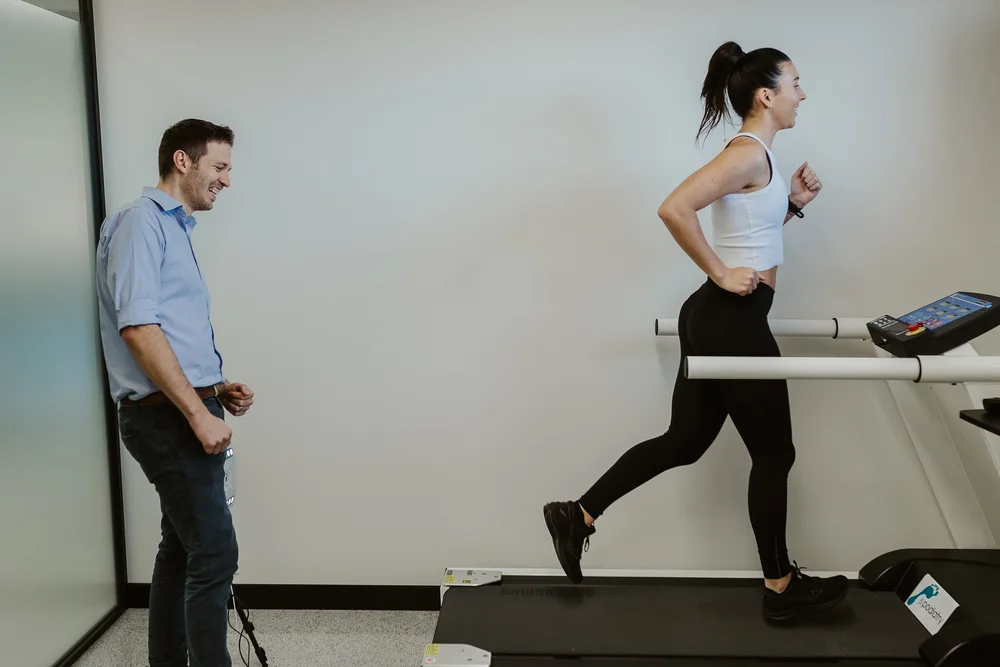 A podiatrist watching a patient run on the clinic treadmill