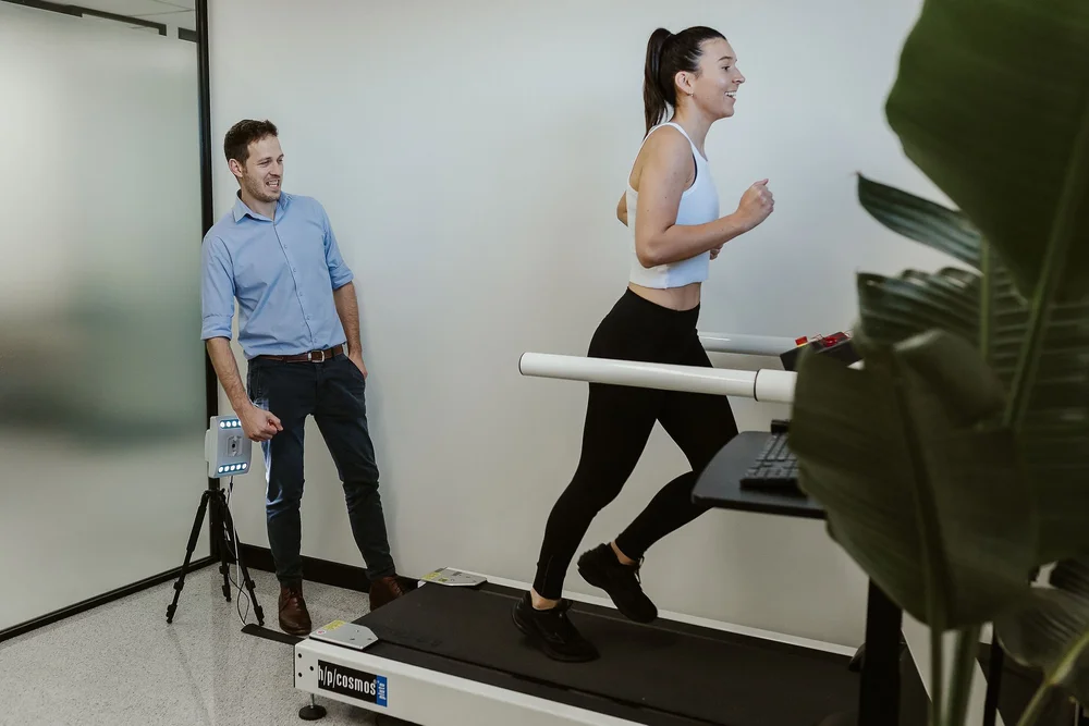 A podiatrist filming a patient running for a gait assessment